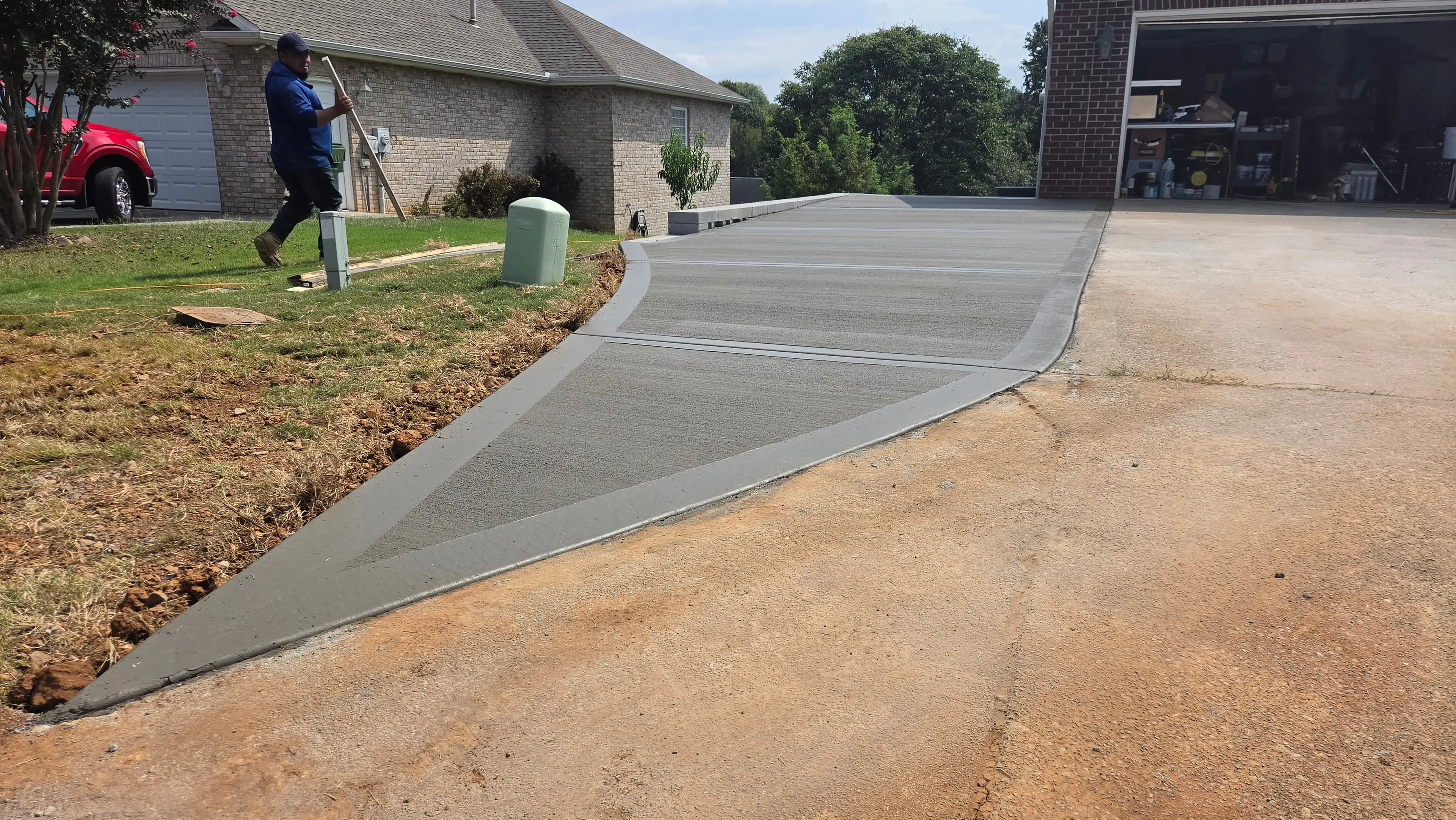 Curved concrete driveway extension being finished