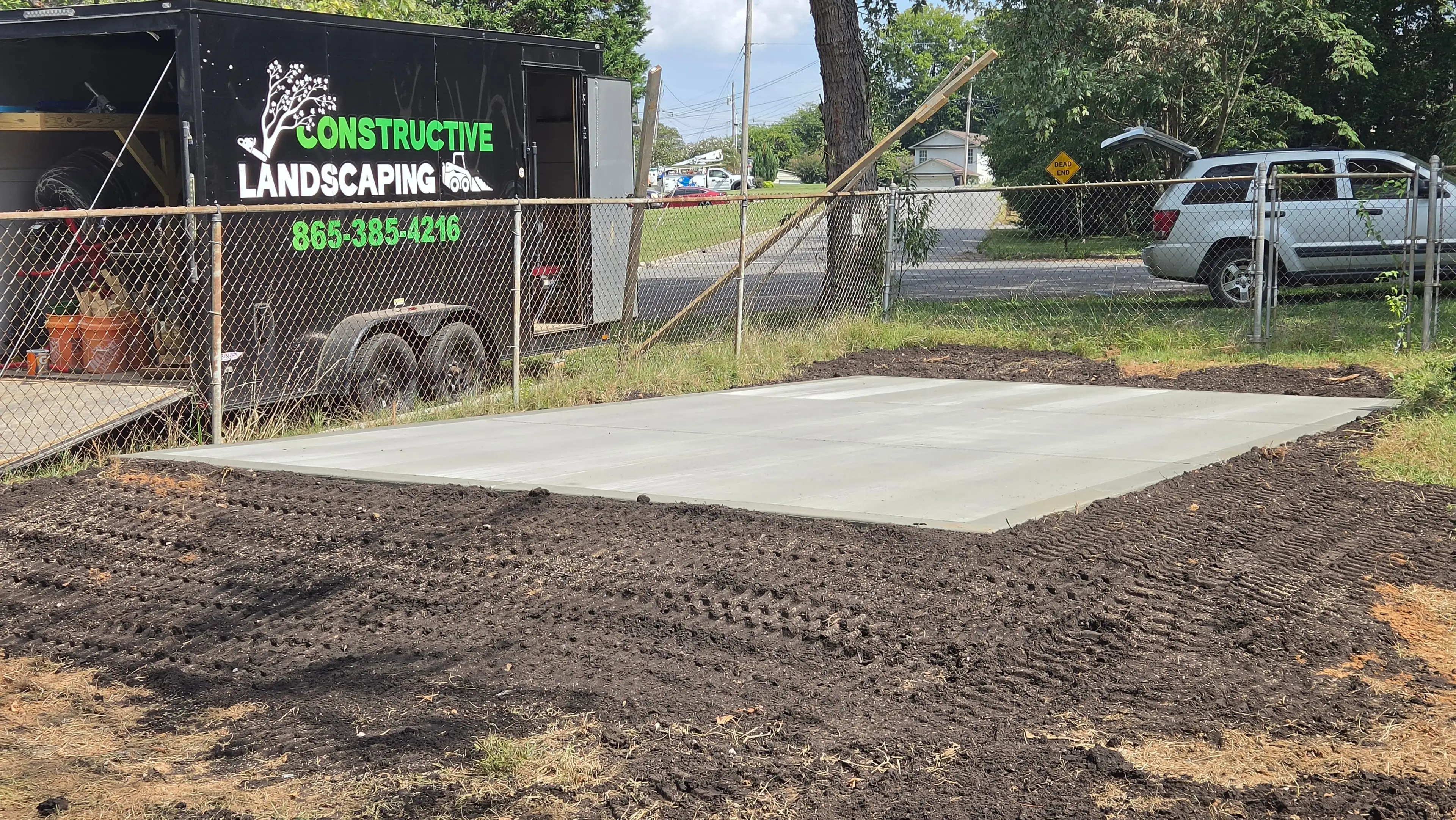 Freshly poured concrete pad with Constructive Landscaping trailer