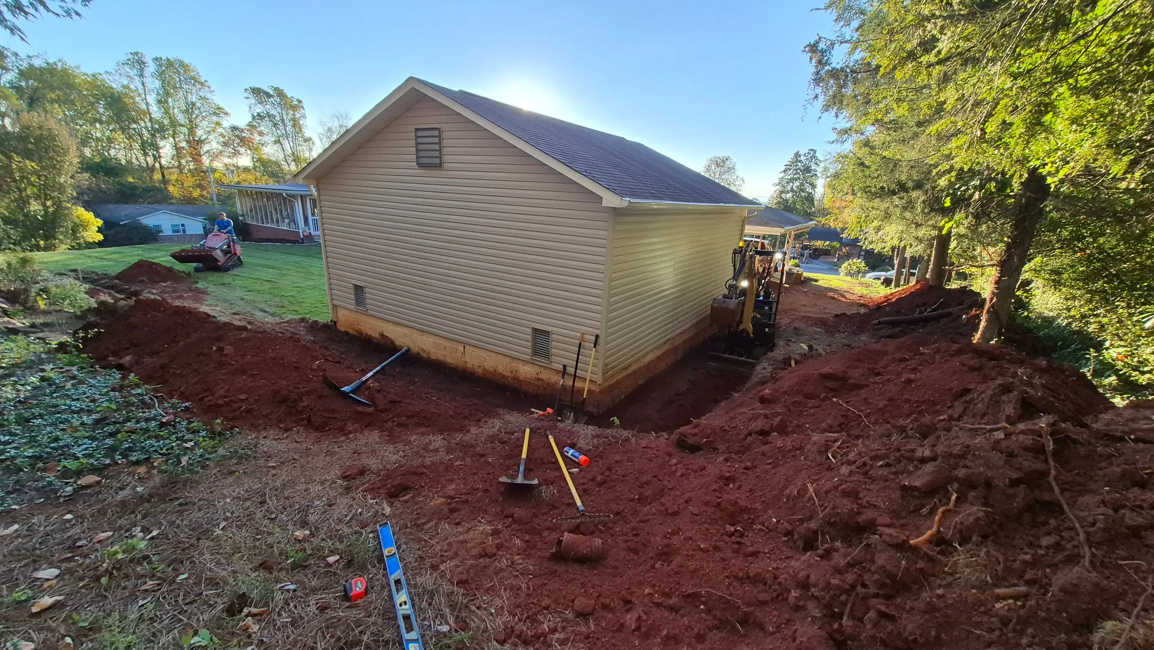 Excavation and grading work in progress around a residential building