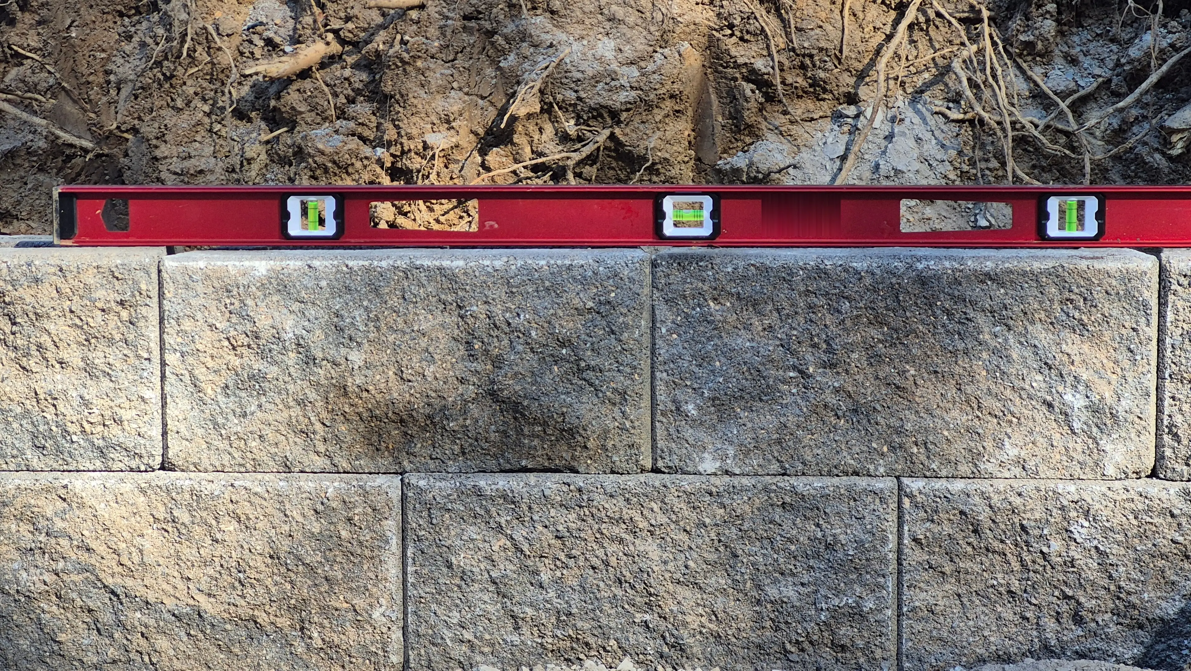 Level on granite block retaining wall during construction