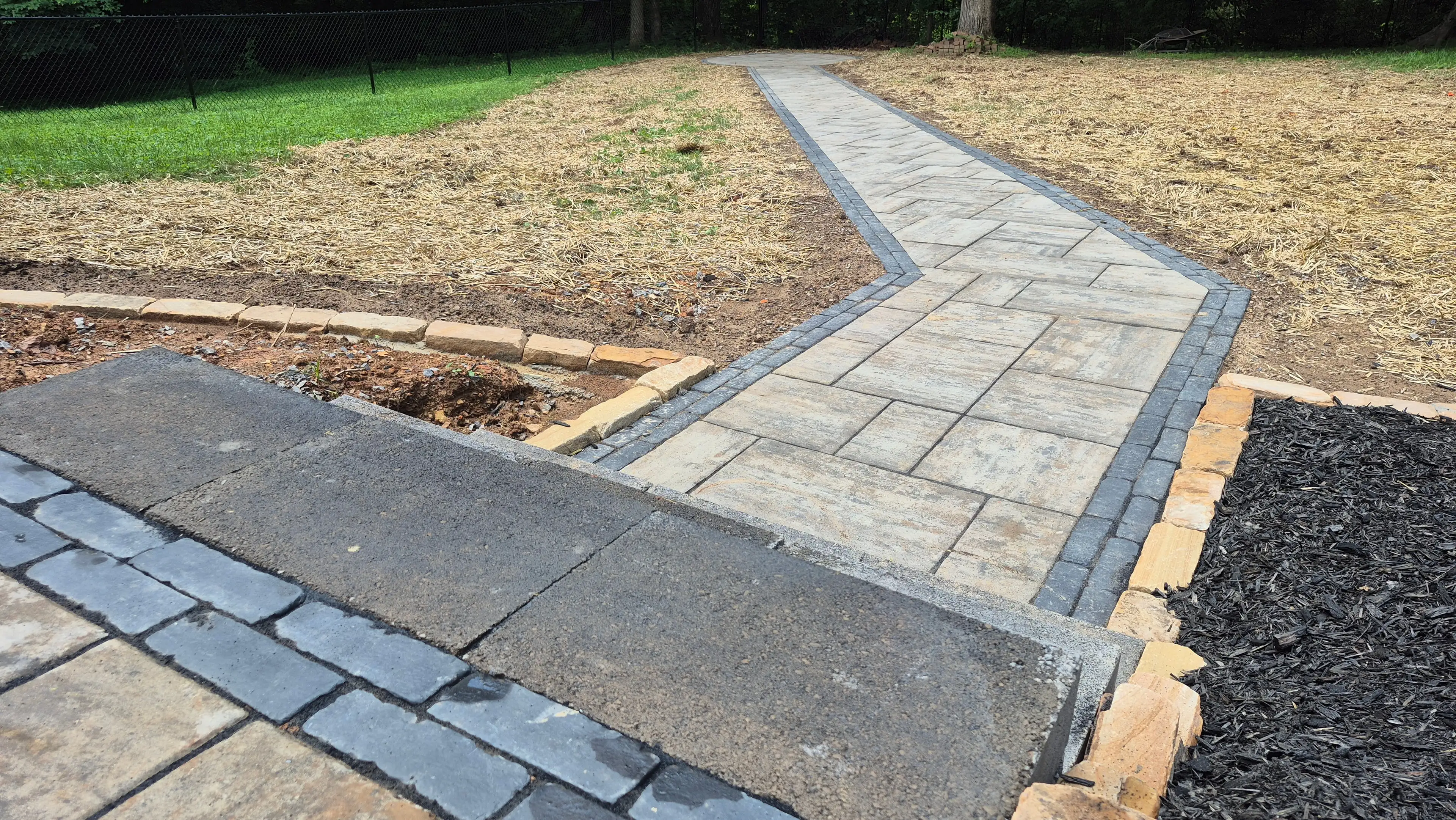 Herringbone paver walkway with mulch bed edging