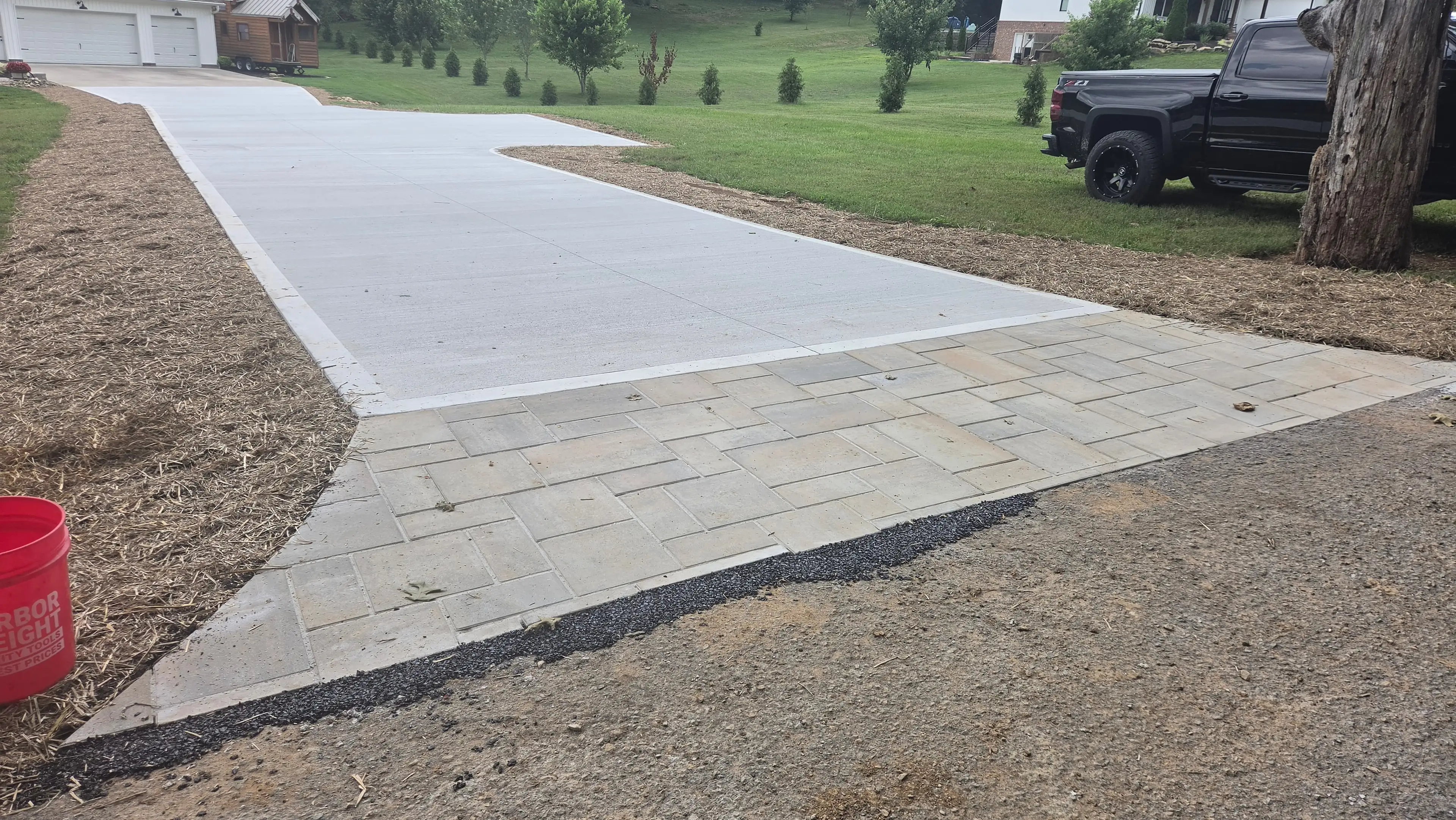 Long concrete driveway with paver apron border