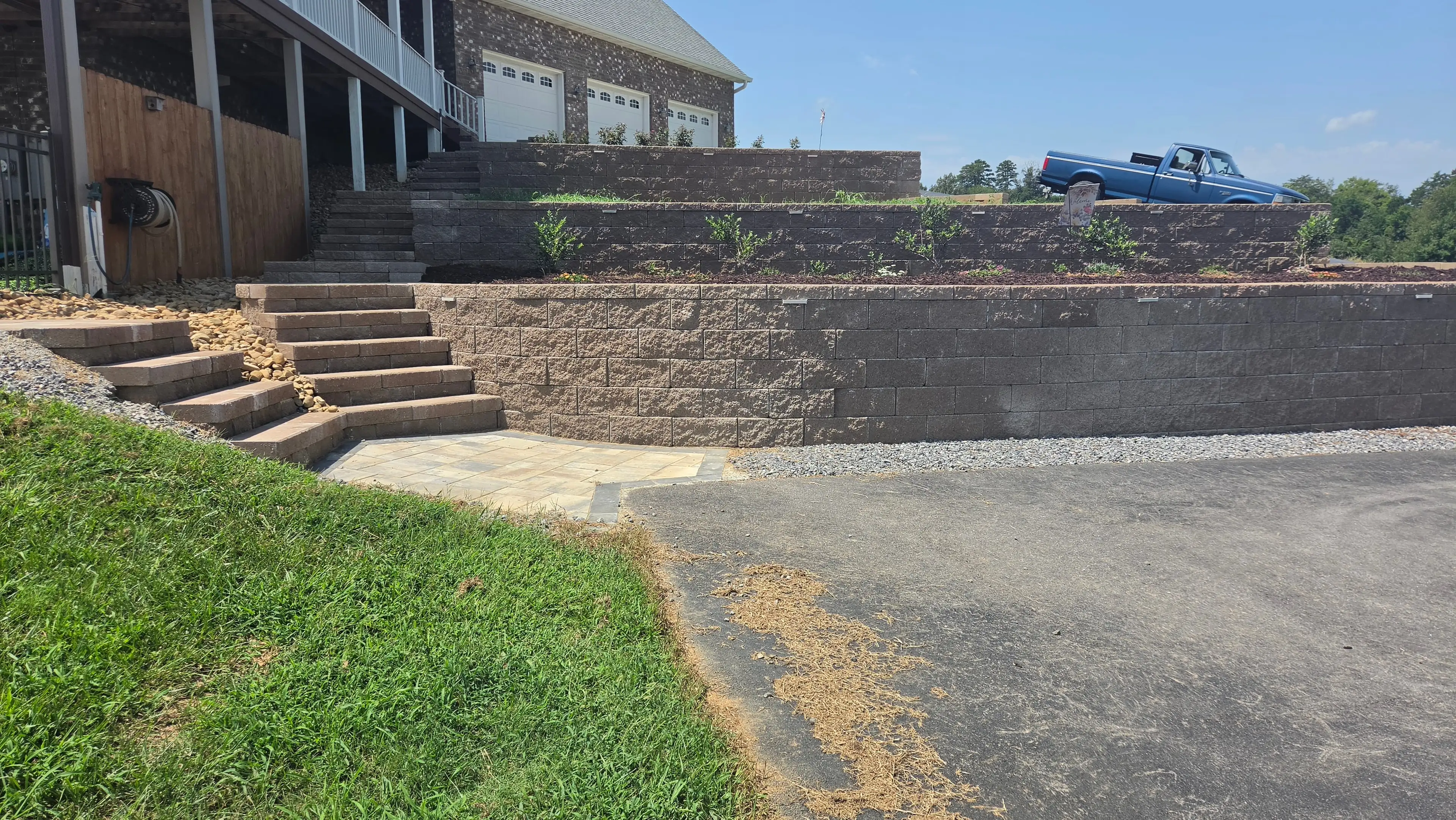 Tiered block retaining walls with paver steps